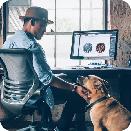 Man with hat and his dog in front of computer